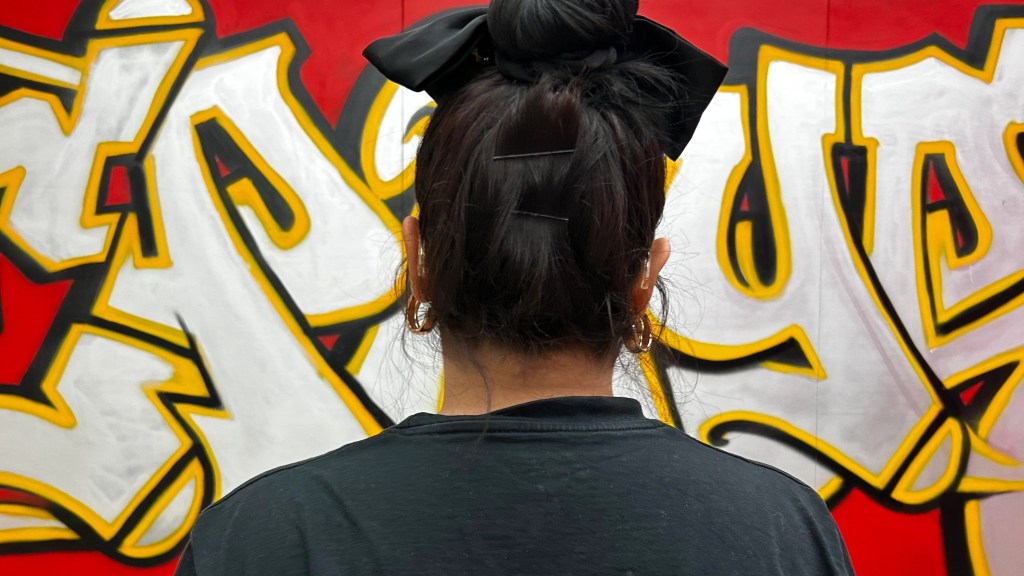 Female looking at a graffiti art at an exhibition in the Saatchi Gallery